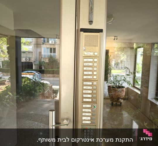 אינטרקום עם לחצנים ומקשים על דלת כניסה
